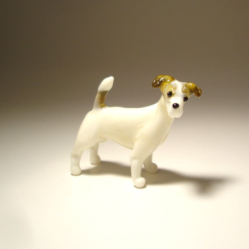 A handmade glass figurine of a Jack Russell Terrier, showcasing its small size and athletic build, with distinct  brown markings.