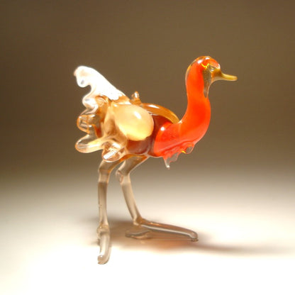 Close-up of a glass ostrich figurine featuring a sleek body and a striking orange neck.