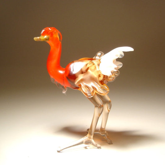 Side view of the glass ostrich, showcasing its elegant posture and the vibrant contrast between the brown and white body and the bold orange neck. 
