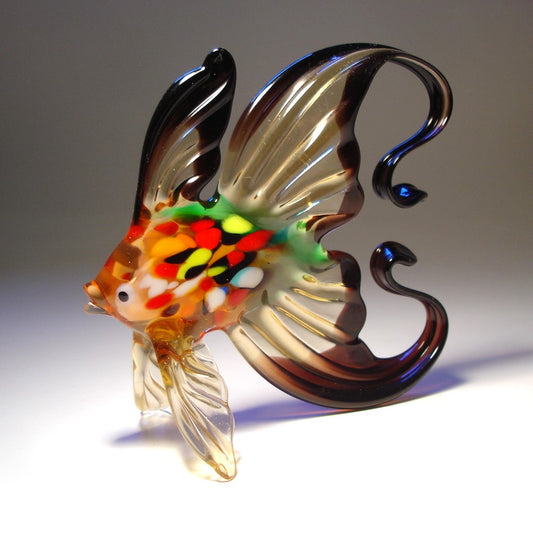 Top view of the black and clear glass fish figurine, showing the intricate coloring on its body and the elegant arch of its tail