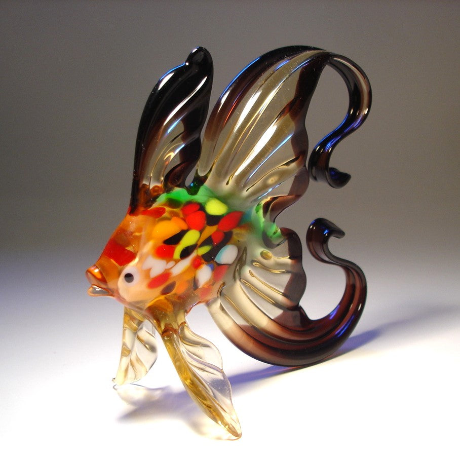Handmade black and clear glass fish figurine with a colorful body, showcasing its arched tail 