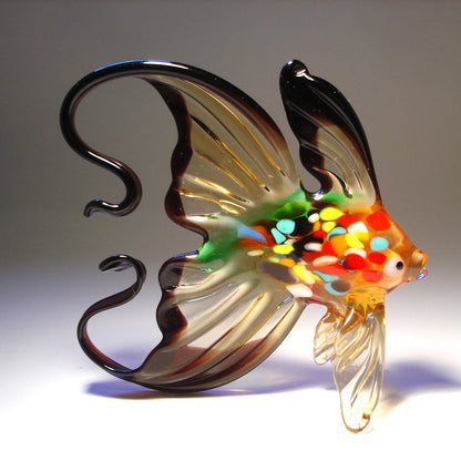 handmade glass fish figurine, highlighting the detailed pattern of colors and the sleek curve of the tail