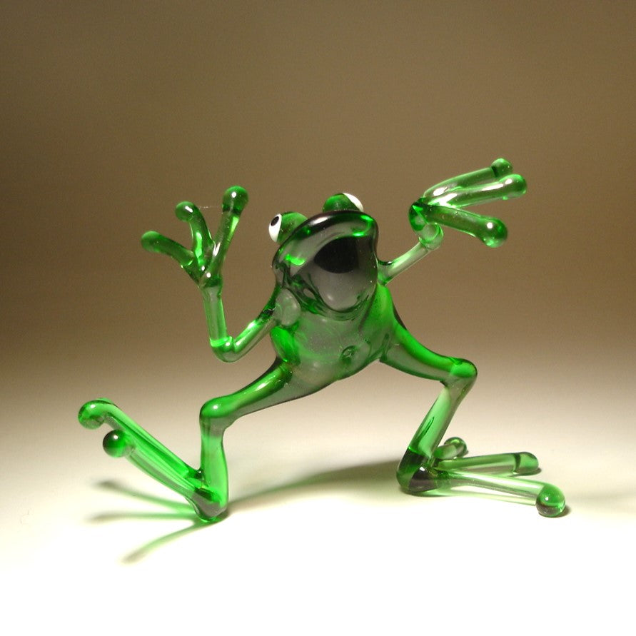 Front view of a glass dancing frog figurine, showing the frog mid-dance with one leg slightly raised and arms extended.