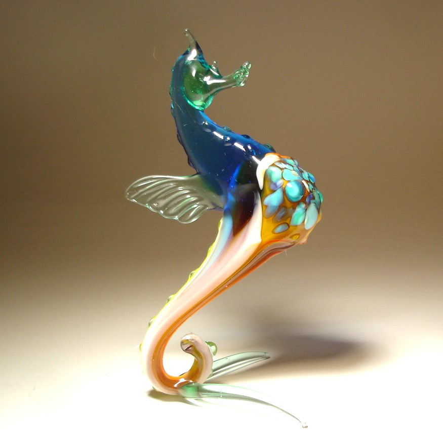 Front view of a glass blue seahorse figurine, showcasing its curled tail and detailed aqua blue textured body.