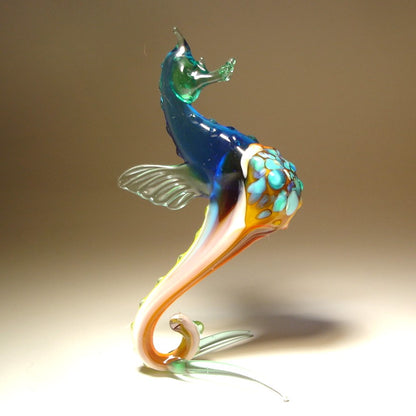 Front view of a glass blue seahorse figurine, showcasing its curled tail and detailed aqua blue textured body.