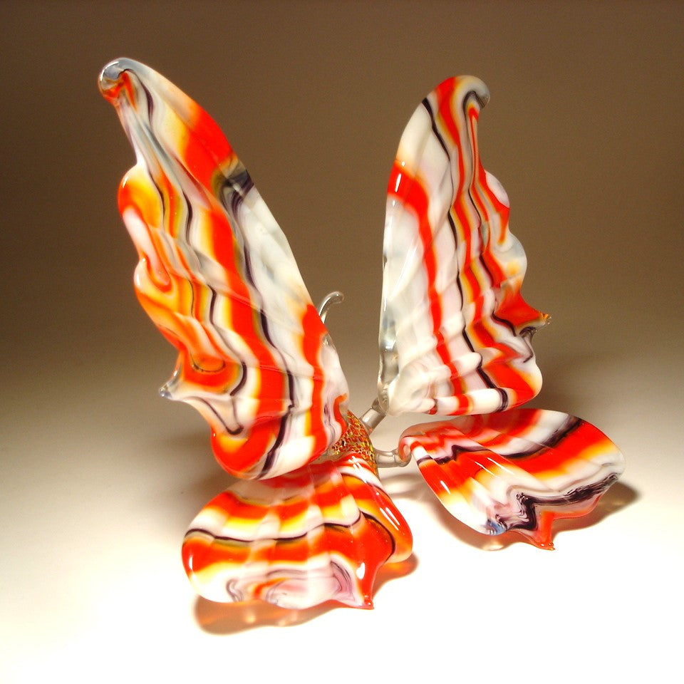 Handmade glass butterfly with red, white and black stripes.