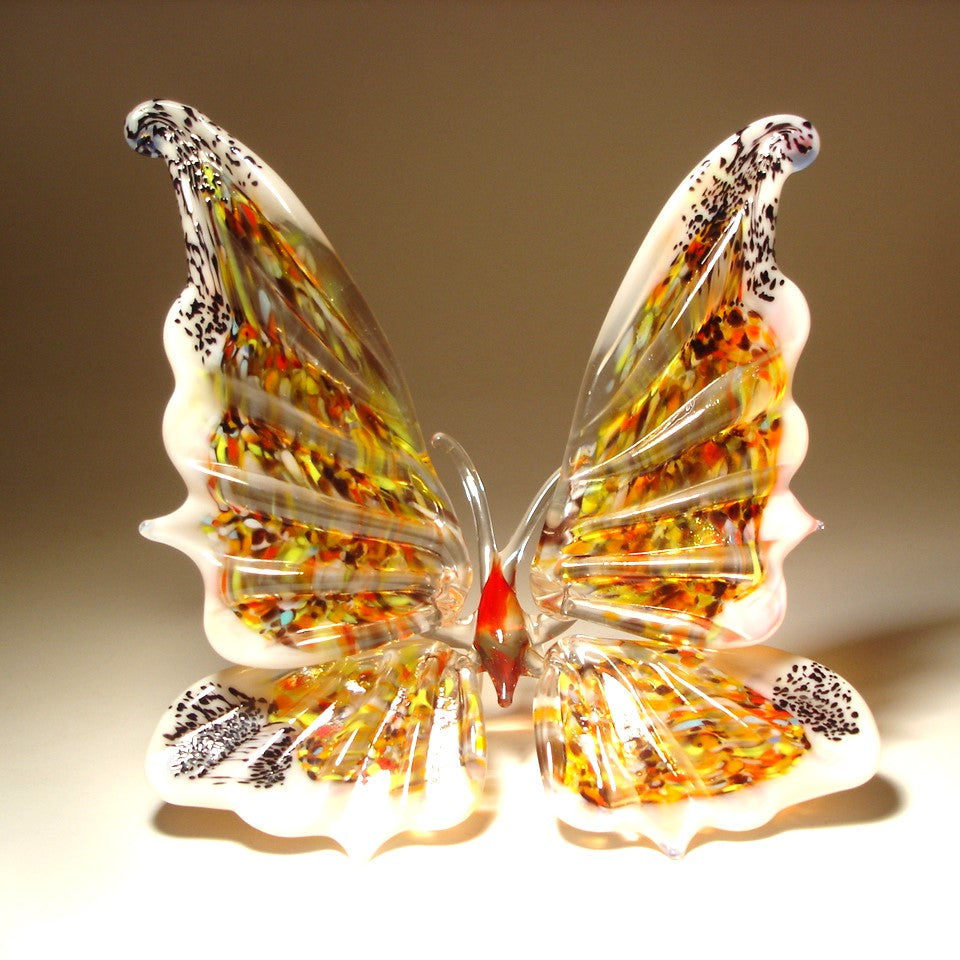 A vibrant white glass butterfly figurine, featuring intricate wing patterns.