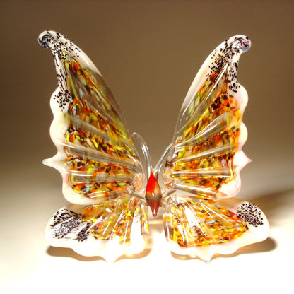 A vibrant white glass butterfly figurine, featuring intricate wing patterns.