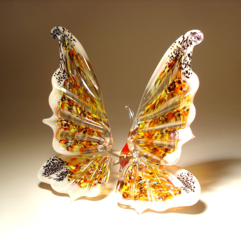 A side angle of the white glass butterfly figurine, emphasizing the elegant curves of its extended outward wings.
