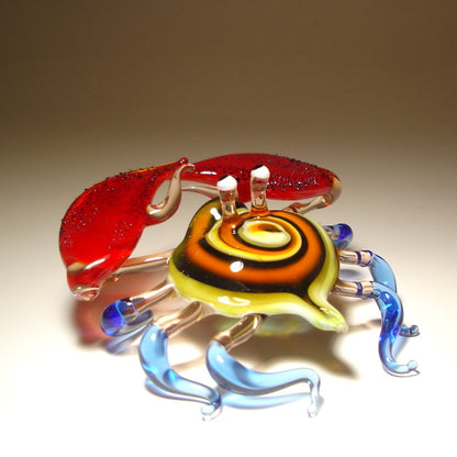 Front view of a glass crab figurine with vibrant red claws, showcasing its detailed colorful shell and legs.
