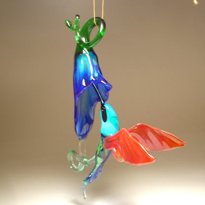 The other view of the blue trumpet flower and green and red hummingbird with a blue head