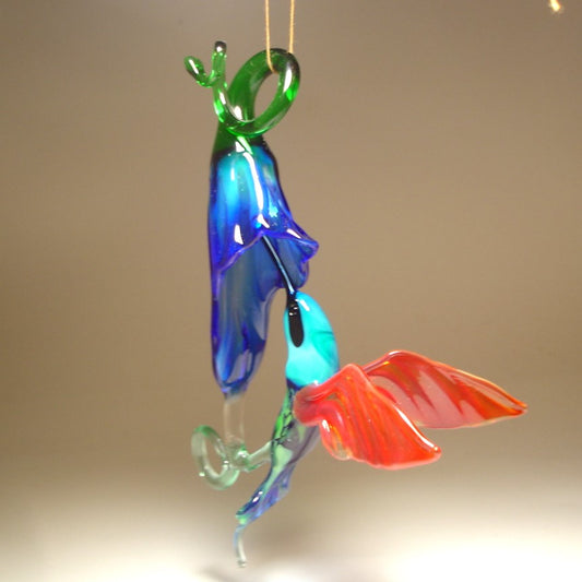 The other view of the blue trumpet flower and green and red hummingbird with a blue head