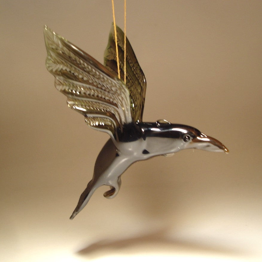 A handcrafted glass raven crow figurine ornament in flight