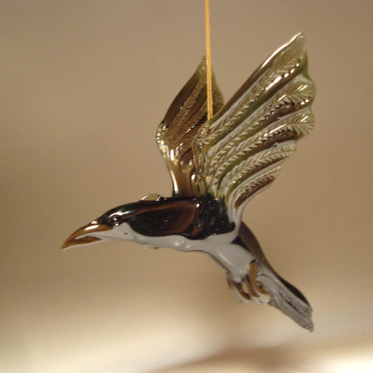 Side view of the glass raven crow figurine, focusing on the fine craftsmanship of its wings and tail feathers.