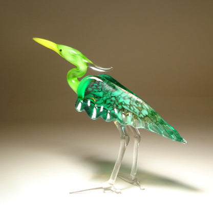 A graceful glass Green Neck Heron figurine standing elegantly with its long neck extended, showcasing detailed feathers in various shades of green and blue.