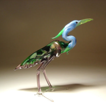 Side view of the glass heron figurine, highlighting the detailed green wings and slender legs.