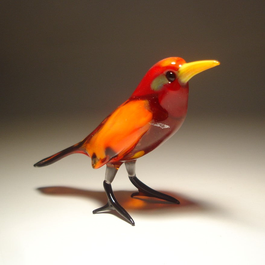 Side view of the glass red bird figurine, highlighting the color of the body in different shades of red.