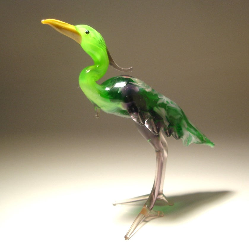 Another side view of the glass heron figurine highlighting its green long neck and back.