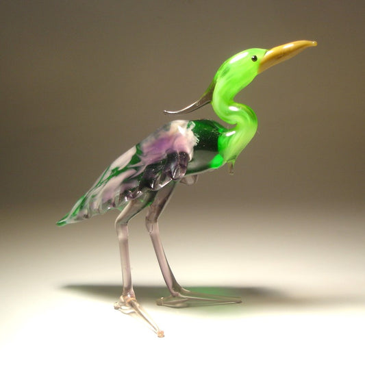 A side view of the glass heron figurine highlighting its green back and intricate feathers on the side of its body.