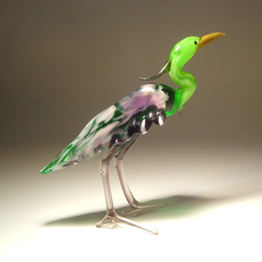 A graceful glass Green Neck Heron figurine standing elegantly with its long neck extended, showcasing detailed feathers in various shades of green and purple.