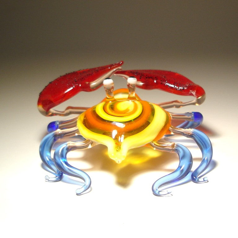 Front view of a glass crab figurine with vibrant red claws, showcasing its detailed colorful shell and legs.