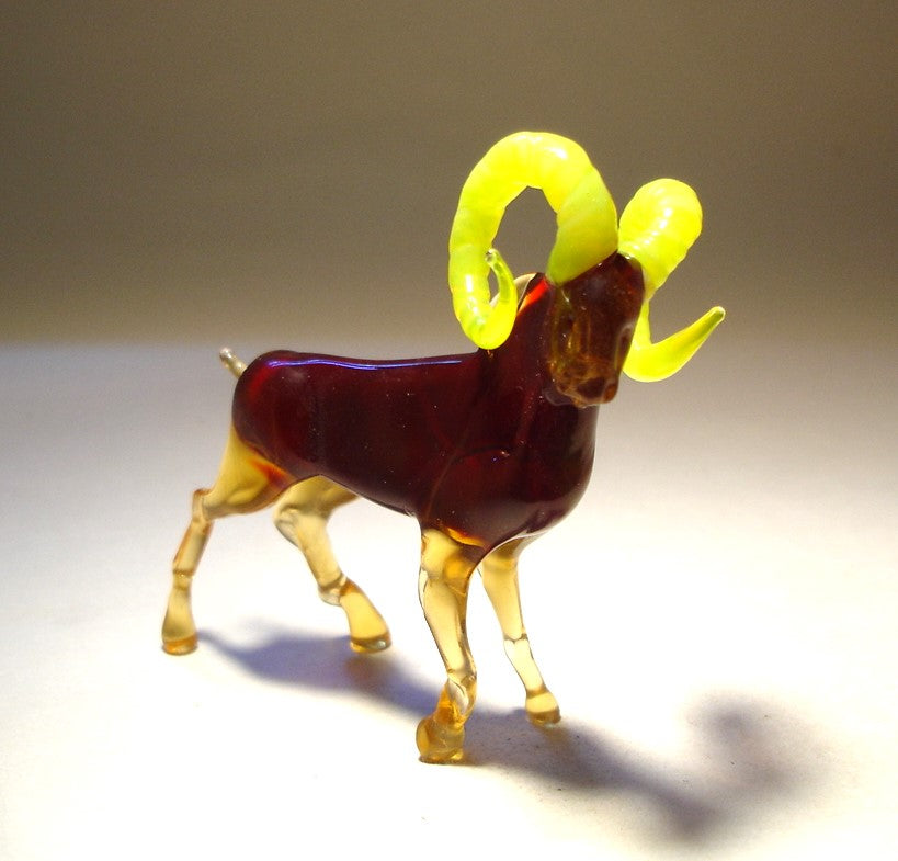 Side view of a dark red goat with a clear brown legs and tail in walking pose.