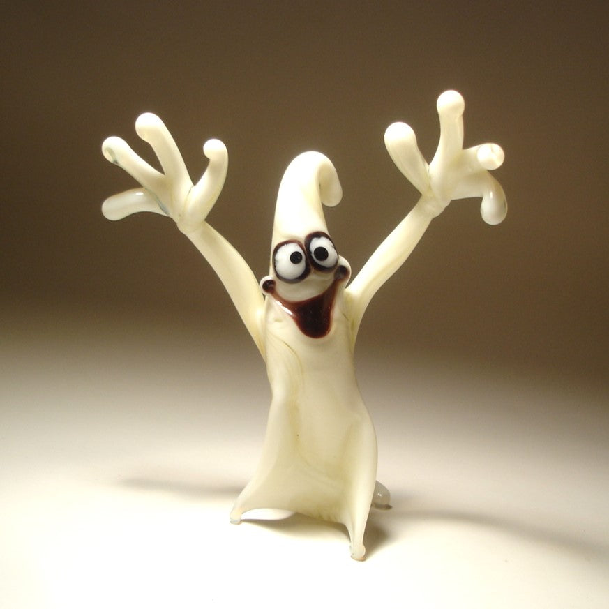 A comical glass white ghost figurine with flowing edges, appearing to float in mid-air.