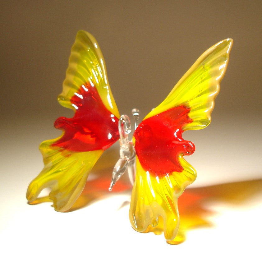 Front view of a yellow and red glass butterfly ornament, featuring a glass hanging loop.