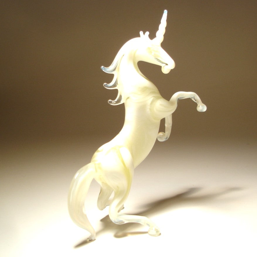 A front view of a glass white unicorn figurine, showcasing its majestic horn, flowing mane, and detailed features.