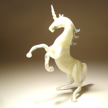A white glass unicorn figurine captured in a rearing pose.