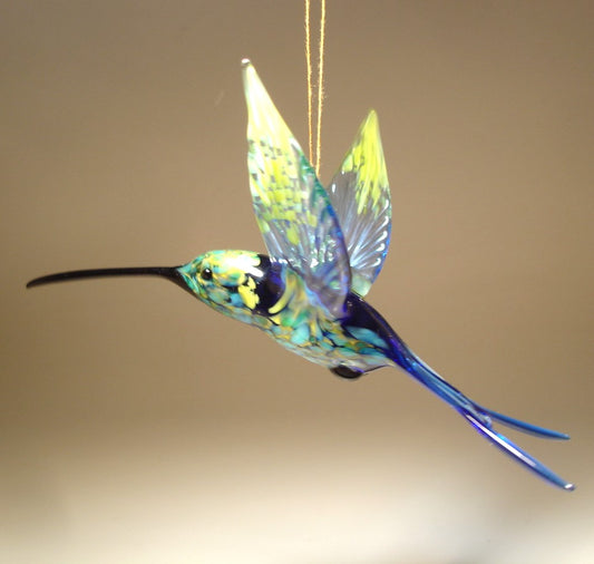 Left side view of the suspended in air hummingbird showcasing a transparent blue wings.