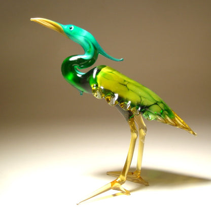 Side view of the glass heron figurine, highlighting the detailed green wings and slender legs.