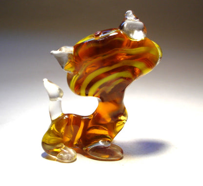 A back view of a glass striped cat figurine, highlighting the unique striped design along its back and clear glass tail.