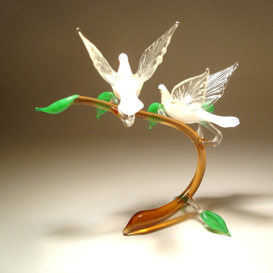 Back view of the glass white doves on a branch figurine, emphasizing the symmetrical arrangement of the white doves.