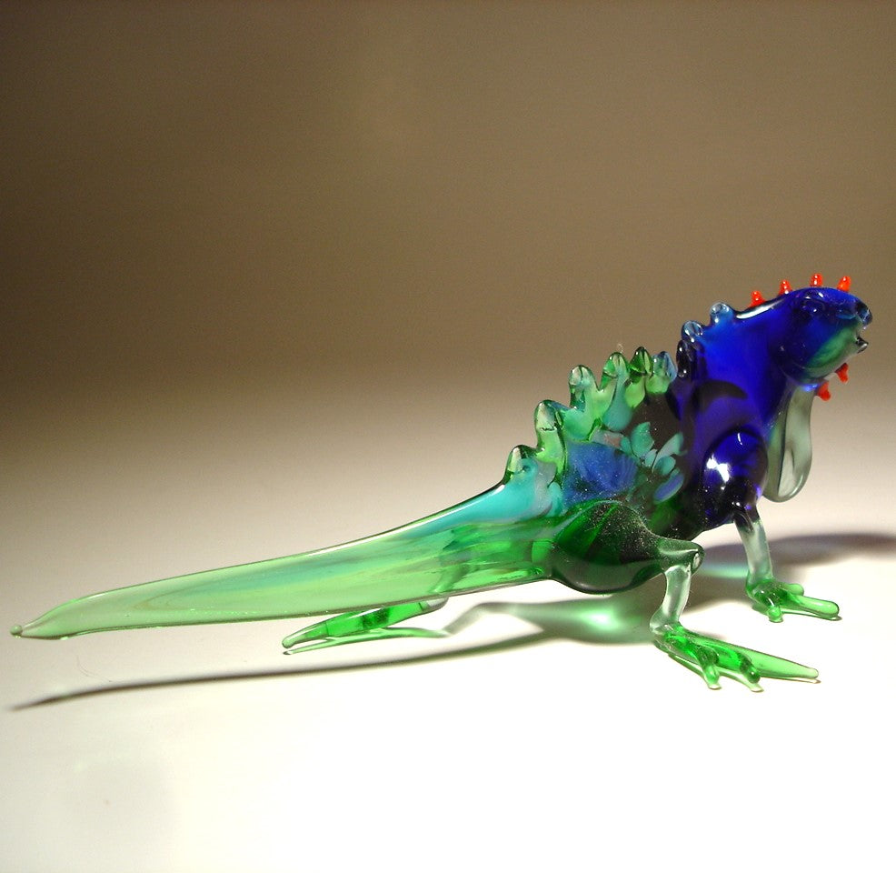 A glass figurine of a Grand Cayman iguana in a blue and green color combination. 