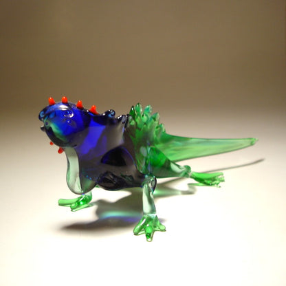 A glass figurine of a Grand Cayman iguana in a blue and green color combination. 