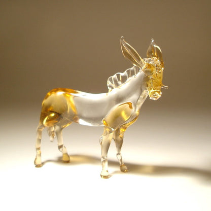 A transparent glass donkey figurine with amber-gold highlights