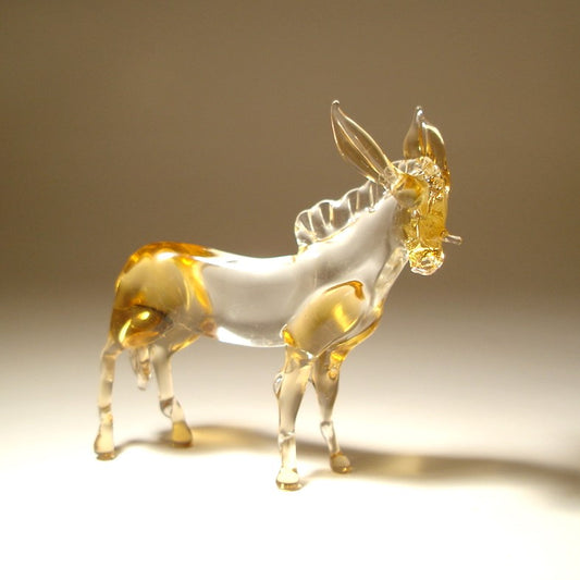 A transparent glass donkey figurine with amber-gold highlights