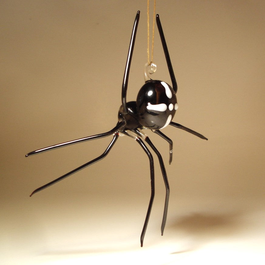 A black spider-shaped hanging ornament with glossy white eye details and a clear glass loop at the top.