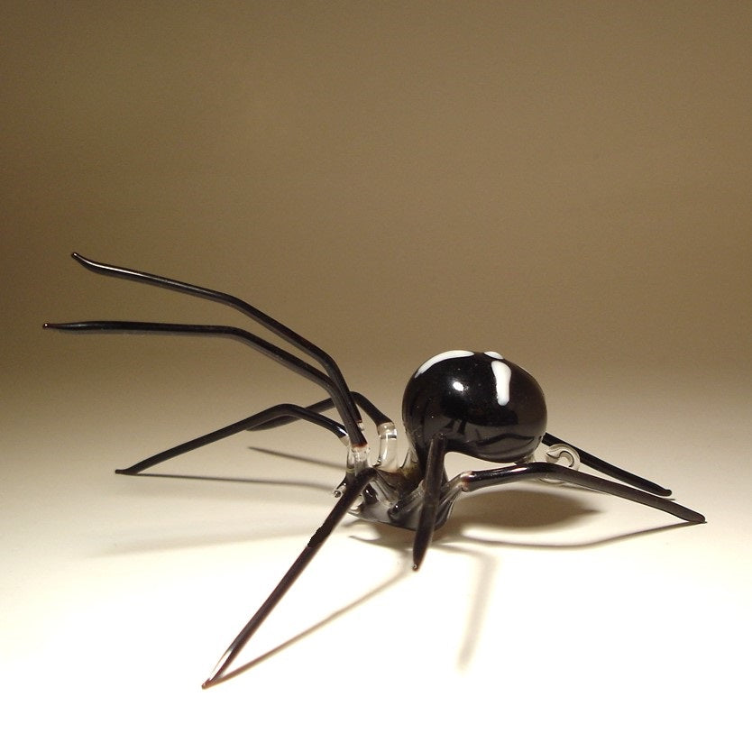 A glossy black spider sculpture with long, slender legs.