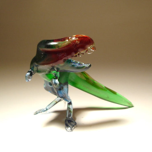 Glass Tyrannosaurus figurine with a turned head and open jaws