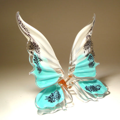 A side view of the white and blue glass butterfly figurine, showcasing its graceful shape and the artistic design of its wings.
