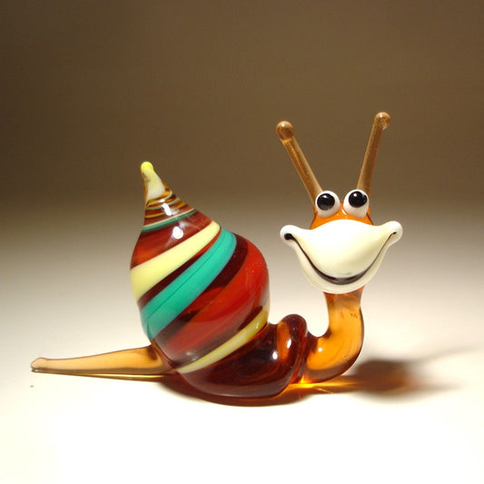 A hand-blown glass snail figurine with a striped shell in red, green, yellow, and brown, and a smiling orange and white face.