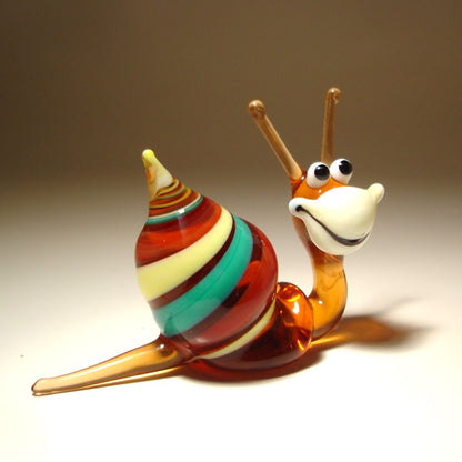 ide view of the Glass Happy Snail Figurine, displaying its colorful spiral shell as it appears to crawl, with its cheerful expression.