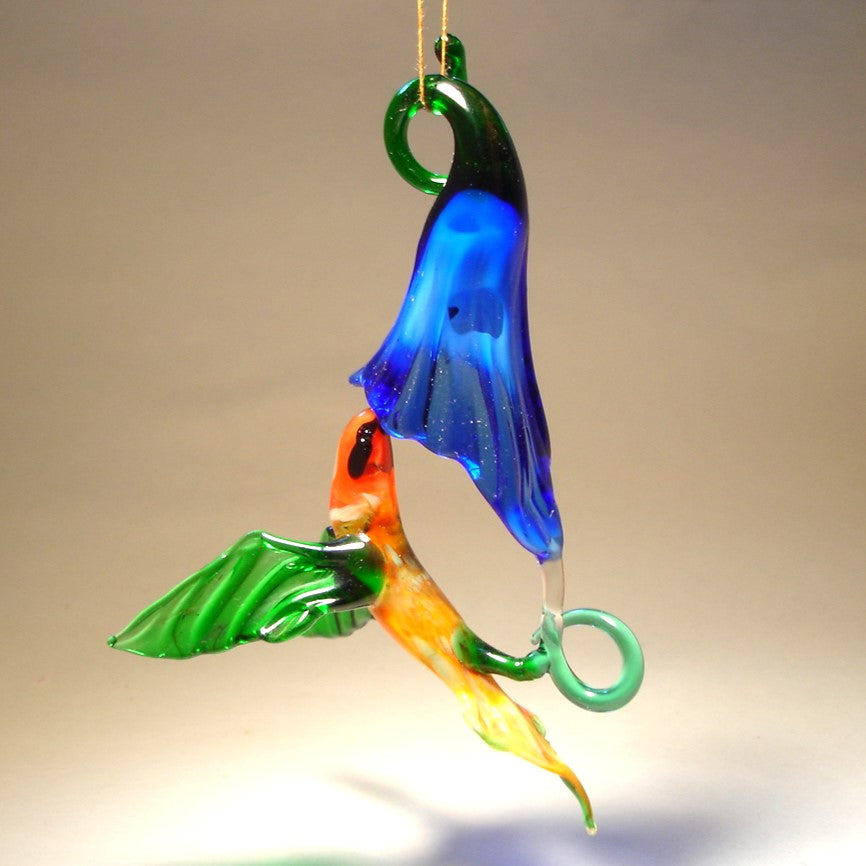 the other view of the blue trumpet flower and green and yellow hummingbird with a red head