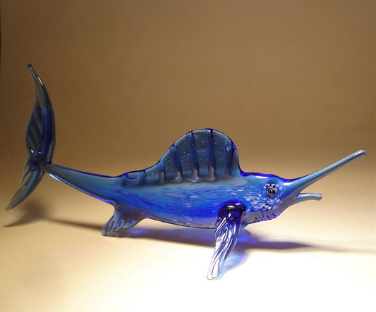 A glass figurine of a blue marlin fish, with a long, pointed bill and a streamlined body.