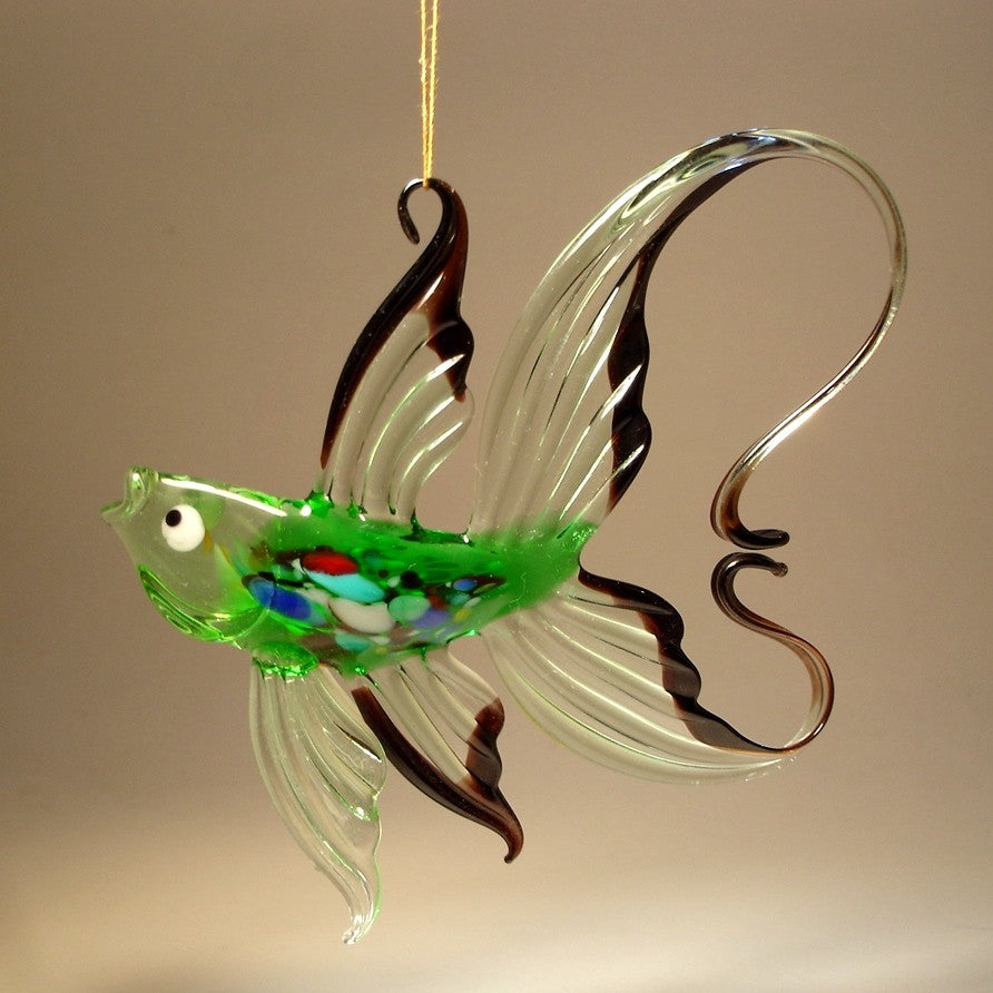 A side profile of the green and black glass fish figurine, showcasing its curved body and arched tail.