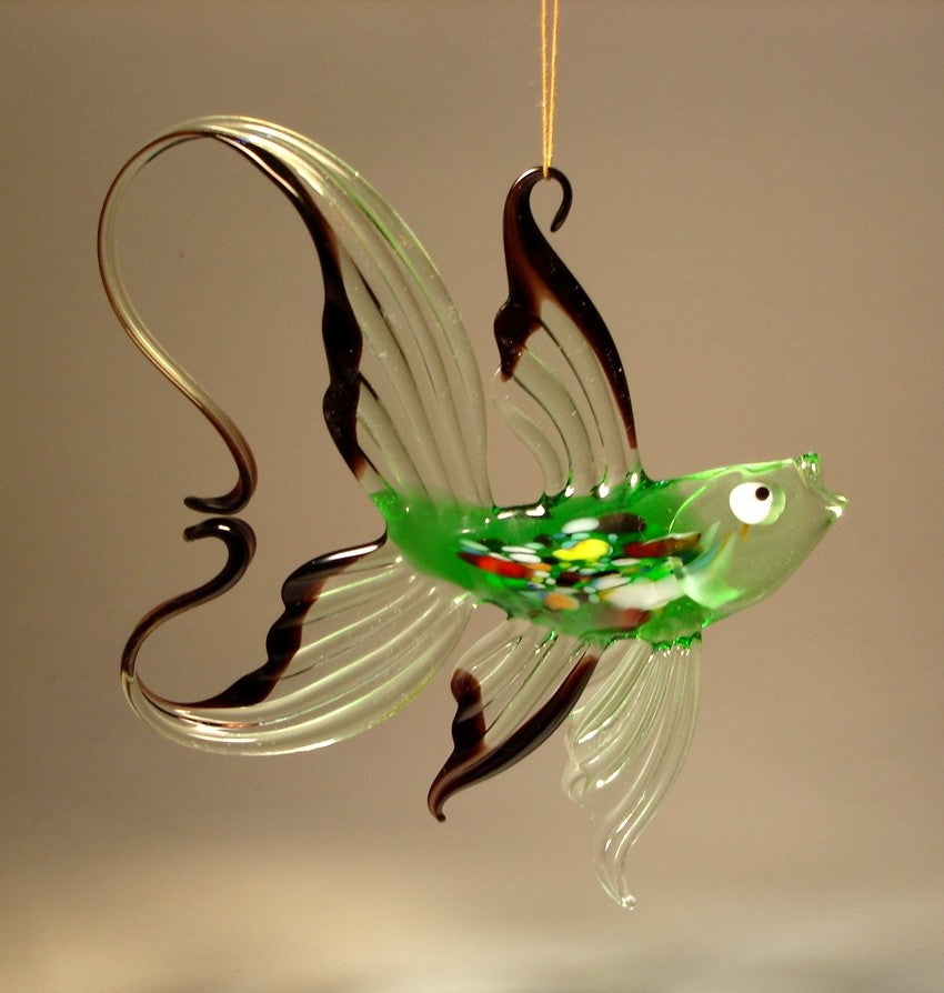 A glass fish figurine with a transparent green fins and elegantly arched tail trimmer in black. 