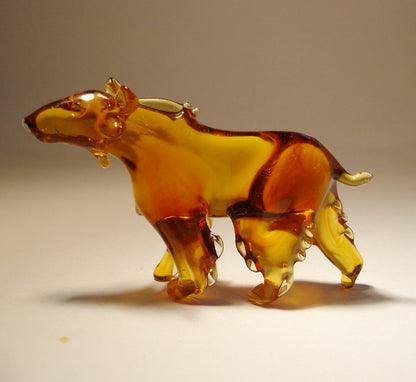 Another side view of a glass brown bear figurine, showing its strong stance and smooth, glossy surface.