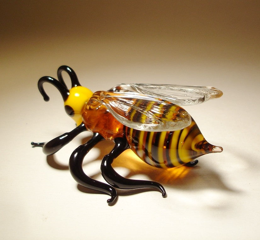 another back view of the glass bee figurine showcasing the black legs and side view of the clear glass wings